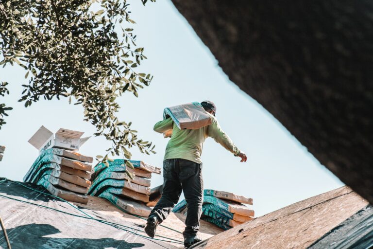 Roofer carrying shingles across a residential roof