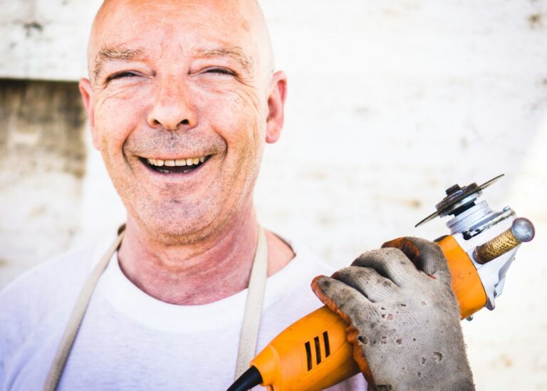 Smiling tradesman holding a grinder
